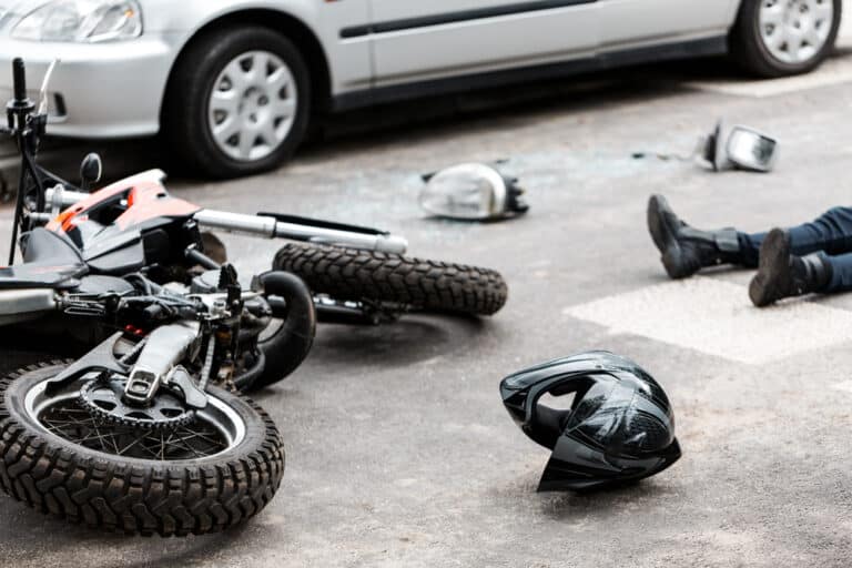 Motorcycle and car collision, helmet on ground