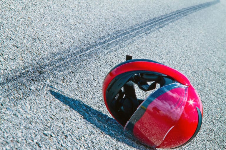 Motorcycle helmet on road near skid marks