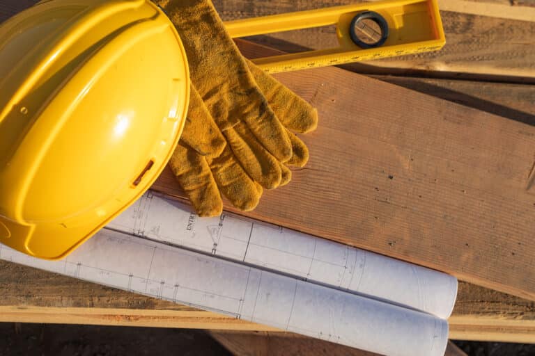 Construction hard hat, level, gloves, wood
