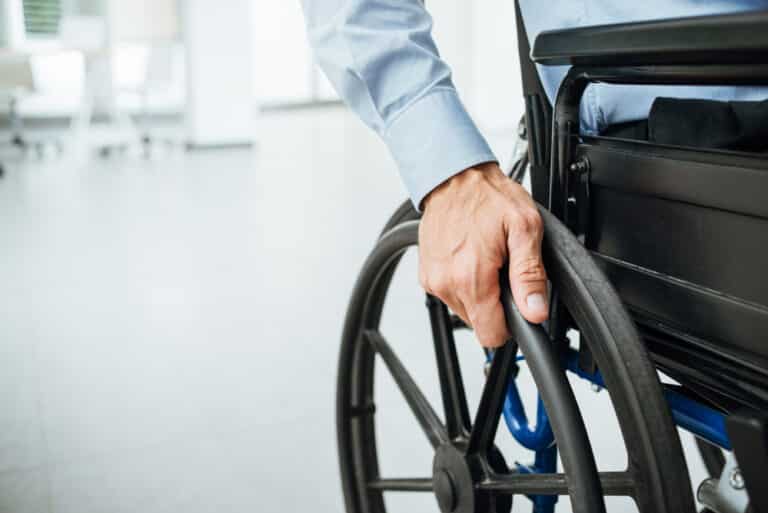 Male hand on wheelchair wheel close-up