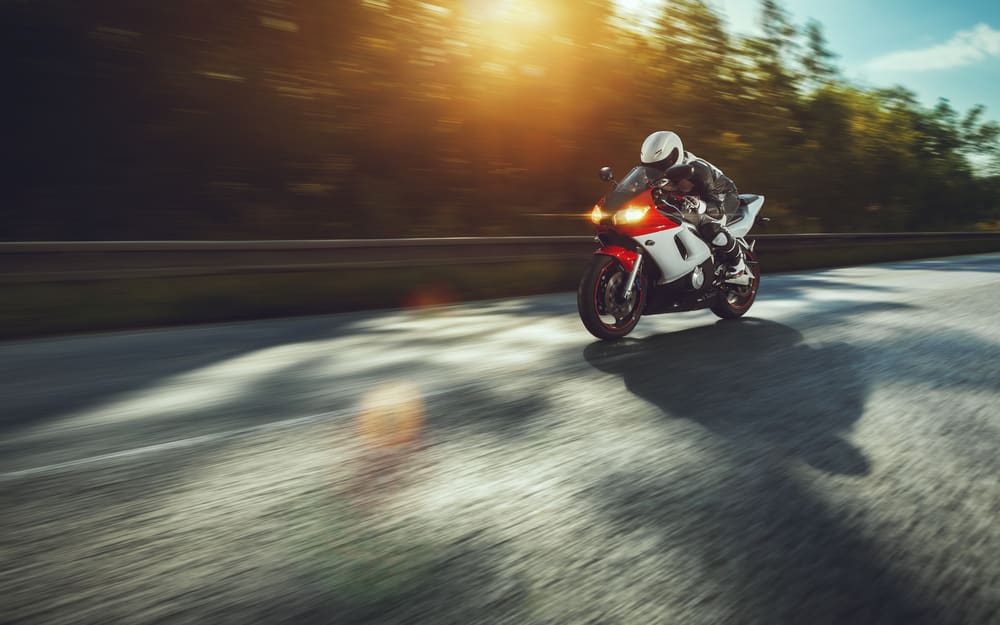 Motorcyclist driving fast on road, blurred