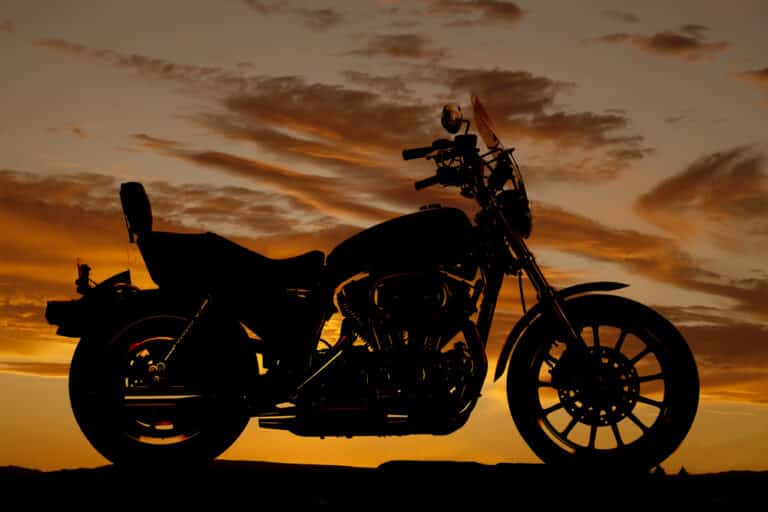 Motorcycle silhouette against sunset sky