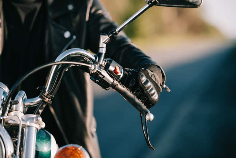 Close-up of hand gripping motorcycle handlebar