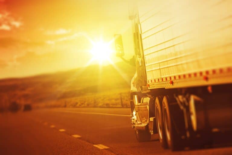 Close-up of semi truck on highway at sunrise