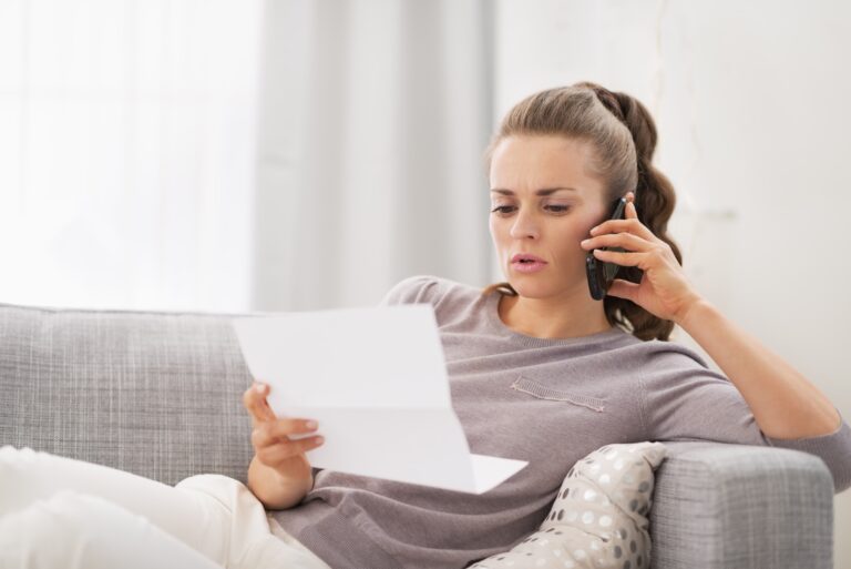 Concerned woman talking on phone, holding paper
