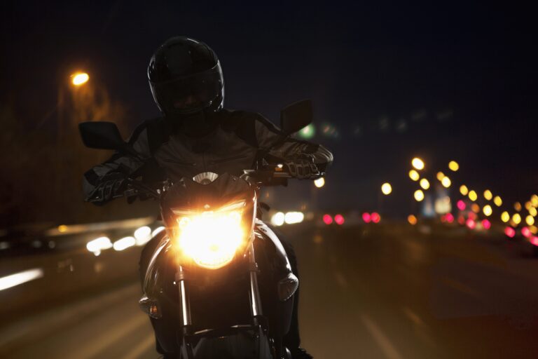 Motorcycle driver on road at night
