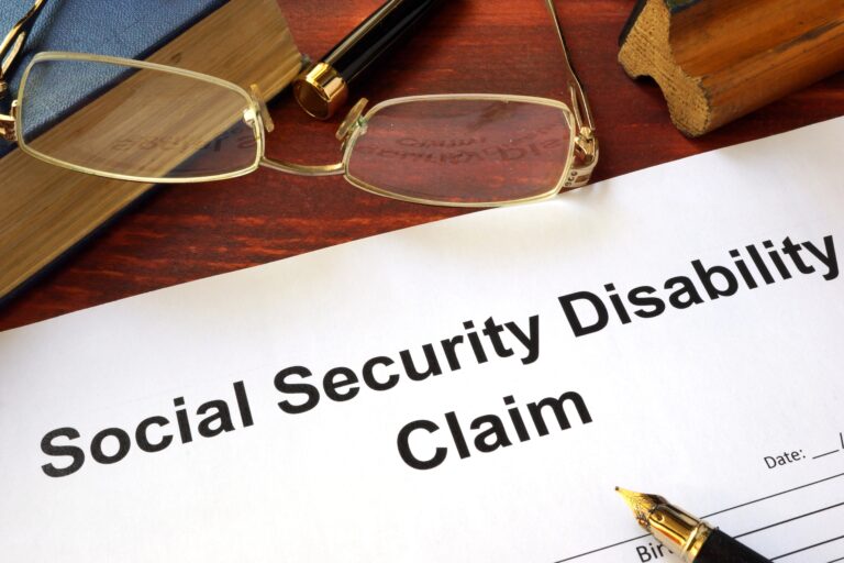 Social Security Disability Claim Heading on Paper Beside Glasses